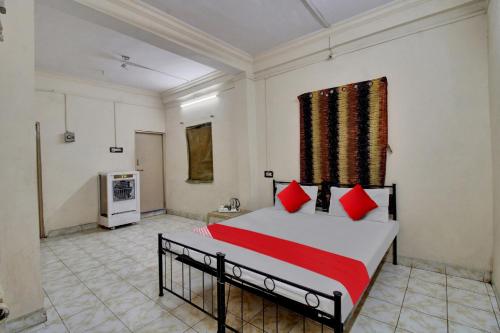 a bedroom with a bed with red pillows at Hotel O Kr Inn in Chandrapur