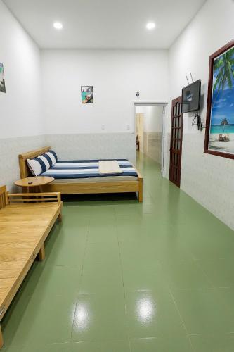 ein Schlafzimmer mit einem Bett und zwei Bänken in einem Zimmer in der Unterkunft Homestay Tuấn Kiệt-Phan Thiết in Ấp Sung Xuân