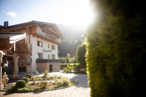 a view of a building with the sun in the background at Hotel Elisabeth, 4 Sterne Superior in Kirchberg in Tirol