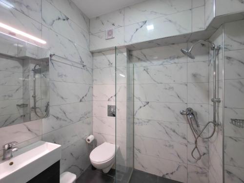 a bathroom with a shower and a toilet and a sink at APOLLON Suites by SDR in Paralia Katerinis