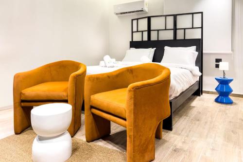 a bedroom with a bed and two chairs at The 2 BDR Sapphire Condo U 5 min to CAI Airport in Cairo