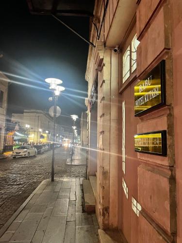 a city street at night with a sign on the side of a building at Hotel BABU in Kutaisi