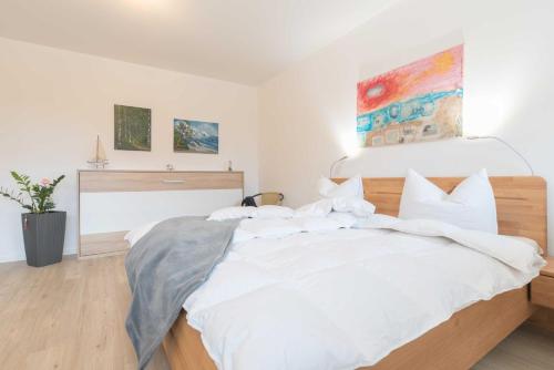 a bedroom with a large bed with white sheets at Exkl App Tilda WLAN, Haustiere Willkommen in Börgerende-Rethwisch