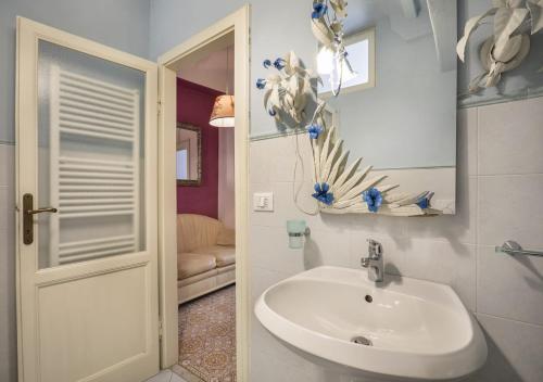 a white bathroom with a sink and a mirror at Fantastico Appartamento Lucca Centro Storico in Lucca