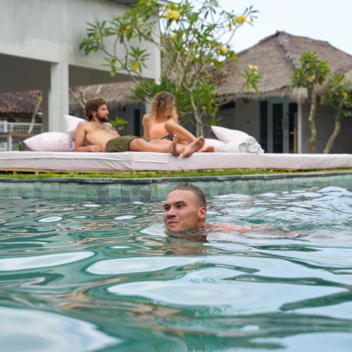 a man in the water in a swimming pool at Dream CoWork Hotel in Kuta Lombok