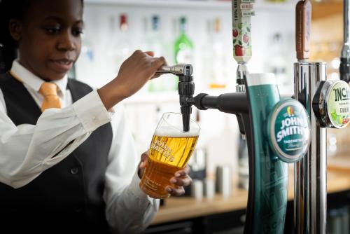 a man pouring a beer into a glass at Biarritz Hotel in St Brelade