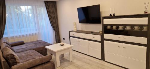 a living room with a couch and a tv at Korsako apartamentai in Šiauliai