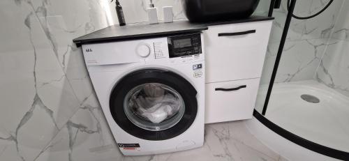 a washing machine in a bathroom next to a toilet at Korsako apartamentai in Šiauliai