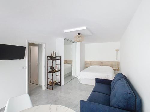 - un salon avec un canapé bleu et un lit dans l'établissement Appartements de Standing Cannes Centre, à Cannes