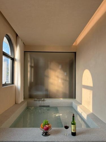 a swimming pool with a bottle of wine and a bowl of fruit at 大有观于All about Yu Hotel in Chongqing