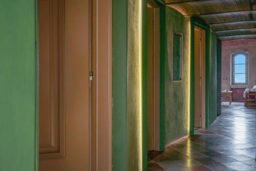 an empty hallway with green walls and a tile floor at Palazzo d'Assi - Guest house in Monforte dʼAlba