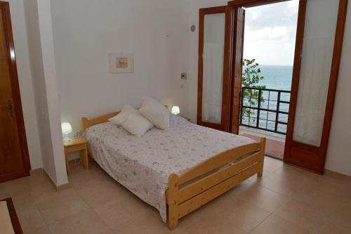 a bedroom with a bed and a view of the ocean at Marco Polo Casa Vacanze in Pollina