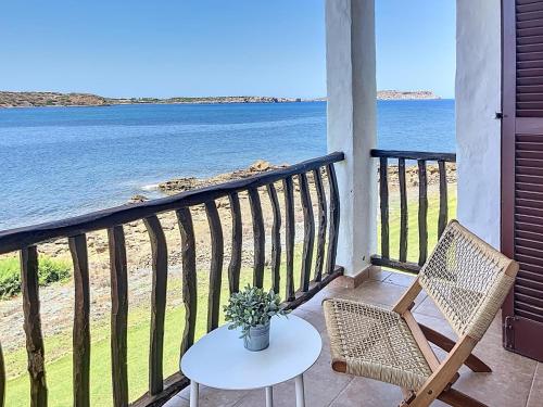 a table and chairs on a balcony with the ocean at Roca Fornells, P131 in Fornells
