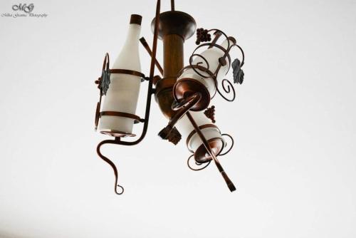 a chandelier with a bunch of wine bottles at Pensiunea Select Moeciu in Moieciu de Sus