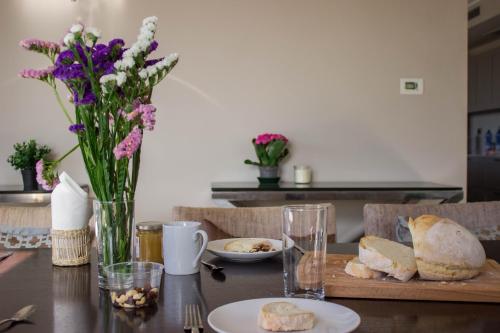 ein Tisch mit einem Schneidebrett mit Brot und Blumen in der Unterkunft Casa Maiella by Rentbeat in Città Sant'Angelo