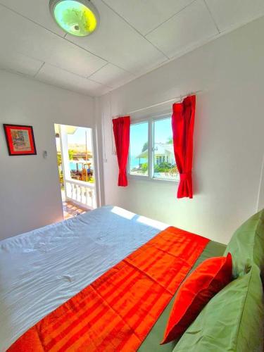 een slaapkamer met een groot bed met rode gordijnen bij Mango Bungalow Tikki Beach Samui in Ban Thung