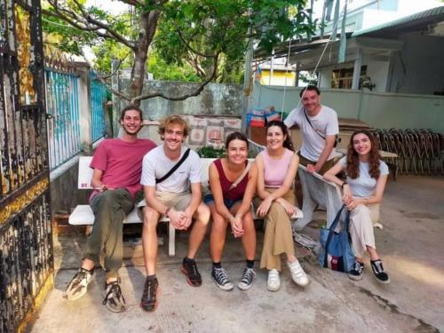 a group of people sitting on a bench at Dorm bed in center with balcony, rooftop and floating market tour by ADORA in Can Tho