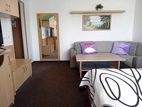 a room with a bed and a couch and a table at Szuperapartman in Zalakaros
