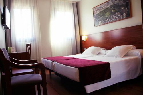 a hotel room with a bed and a chair at Hotel Reus Park in Reus