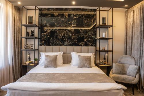 a bedroom with a large bed and a chair at Family Hotel The View & SPA in Tsigov Chark