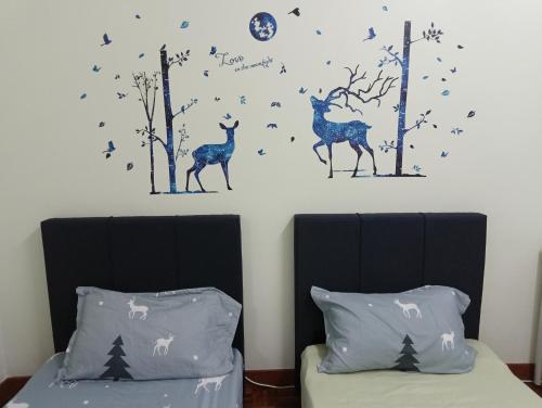 a bedroom with two beds with trees and deer decals at Heart Bentong Guest House 文冬心宿民宿 Bentong Homestay in Bentong