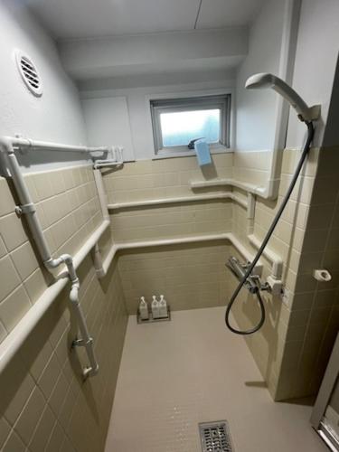 a bathroom with a shower with a window at フロンティアコート105号室 in Nagoya