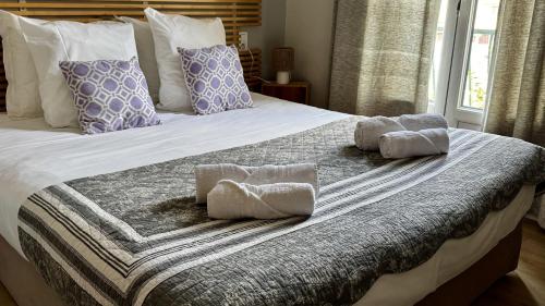 una camera da letto con un letto con asciugamani sopra di Le Bassin Hôtel Restaurant a LʼIsle-sur-la-Sorgue