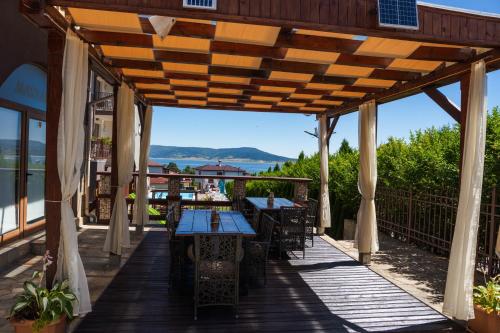 a wooden patio with tables and chairs on a deck at Family Hotel The View & SPA in Tsigov Chark