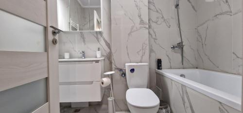 a white bathroom with a toilet and a bath tub at Flavius apartament 's 11 in Cluj-Napoca