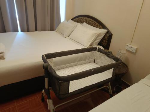 a bedroom with a bed with a crib at 3 BEDROOM SEAVIEW CONDO @ GLORY BEACH RESORT, PORT DICKSON in Port Dickson