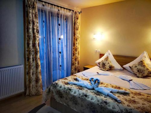 a room with a bed with two people laying on it at Pensiunea Select Moeciu in Moieciu de Sus
