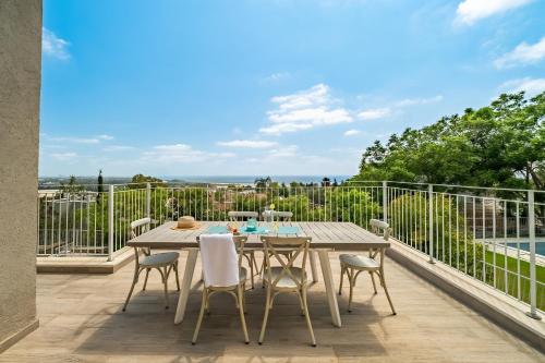 a patio with a table and chairs on a balcony at Rosh HaNikra Garden Villa Retreat by Sea N' Rent in Sulam Tsor