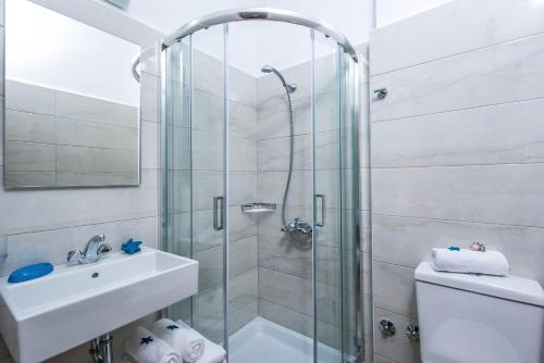 a bathroom with a shower and a sink and a toilet at Floral Hotel in Hersonissos