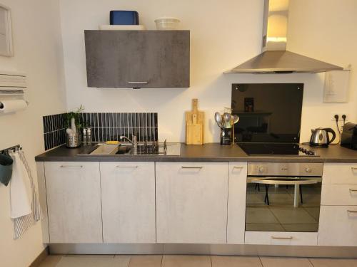 a kitchen with a sink and a counter top at Le Terramon - Appartement 4 personnes in Orbey