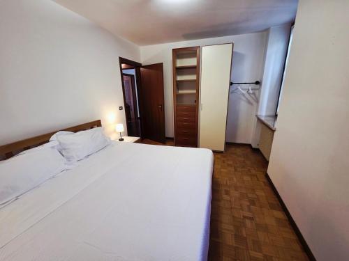 a bedroom with a large white bed and a closet at Tricesimo Appartamento Suite in Centro Storico in Tricesimo