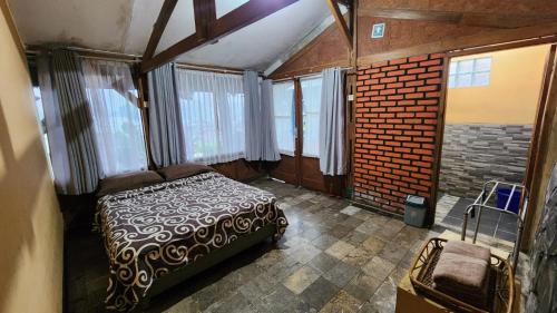 a bedroom with a bed in a room with windows at Nur Alam Hotel Lembang in Lembang