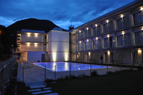 a building with a swimming pool at night at Hotel Vischi in Domaso