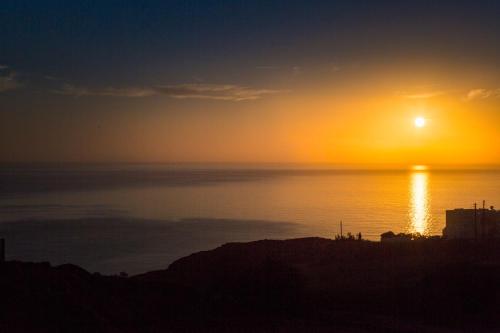 a sunset over the ocean with the sun in the sky at Desiterra Resort & Spa in Fira