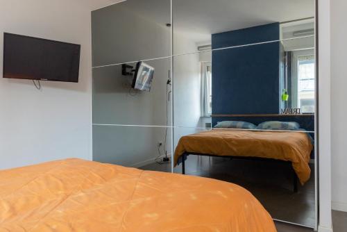 a bedroom with a bed and a tv on a wall at Centralissimo a due passi dal mare in Follonica