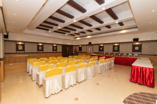 a banquet hall with yellow and white tables and chairs at Hotel Luciya Palace in Trichūr