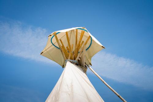a white tower with an umbrella on top of it at Briedžio sapnas in Sudervė