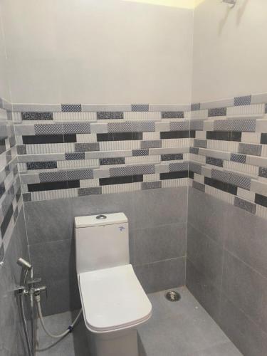 a bathroom with a white toilet in a room at Hotel PG House in Varanasi