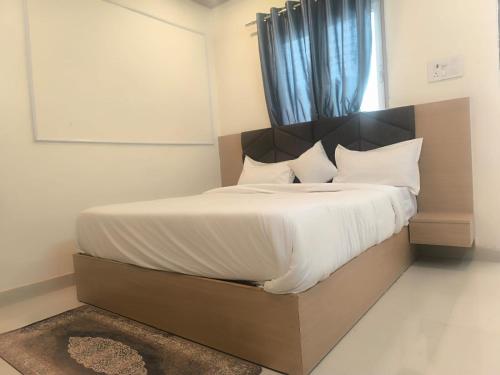 a bedroom with a bed with a wooden headboard at Hotel PG House in Varanasi
