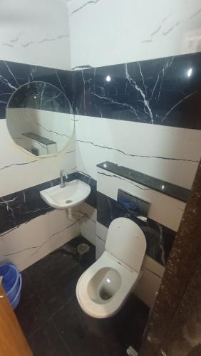 a bathroom with a white toilet and a sink at Hotel kingdom in Indore