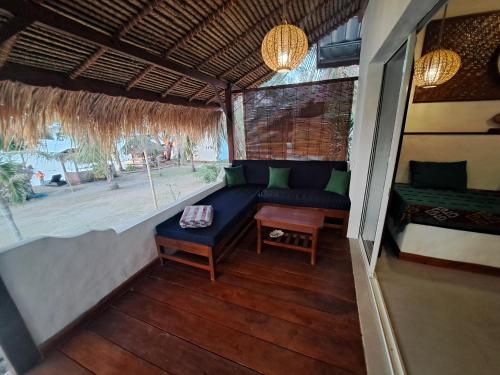 a living room with a couch and a table at Palmyra Indah Bungalows in Sekotong