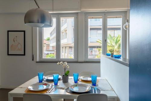 a dining room table with blue glasses and blue dishes at Centralissimo a due passi dal mare in Follonica
