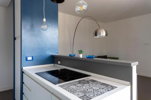a kitchen with a stove and a blue wall at Centralissimo a due passi dal mare in Follonica