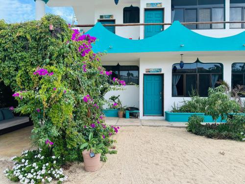 a house with purple flowers in front of it at CABO BOHEMIA Tropical Garden Studios in Cabo San Lucas