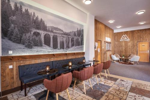 a restaurant with tables and chairs and a painting on the wall at Hotel Telgárt - Turistické ubytovanie in Telgárt