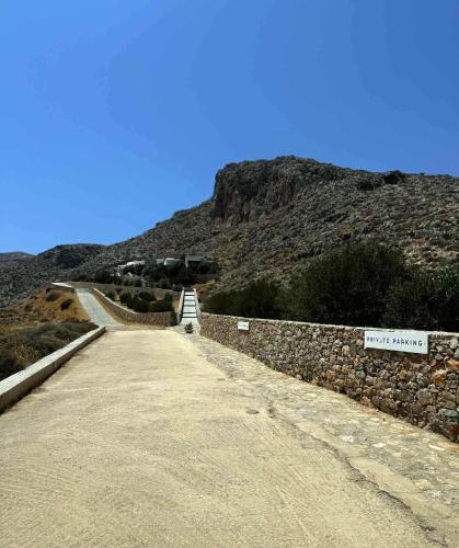 a dirt road with a mountain in the background at Sirokos in Karavostasi